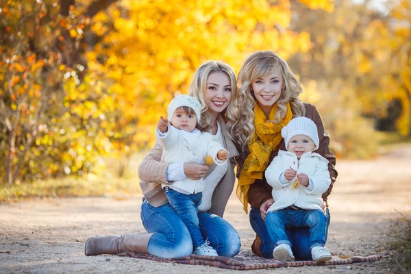 Moms and kids for a walk in the park in autumn — Stockfoto