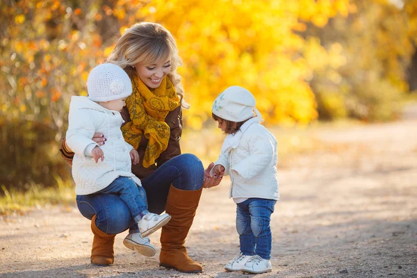 Happy mother with children in autumn park — Stock Photo, Image