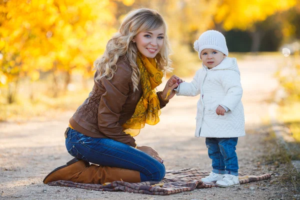 Мама и дочь отдыхают в парке осенью — стоковое фото