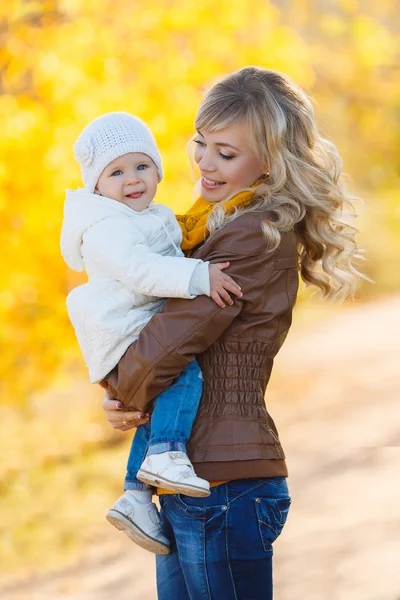 Mom and daughter resting in a park in autumn — Stock Photo, Image