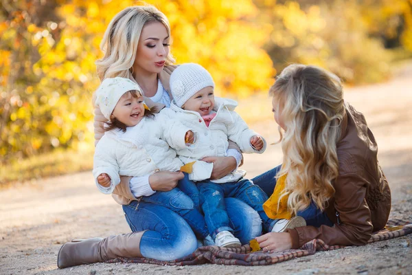 Moms and kids for a walk in the park in autumn — Stockfoto
