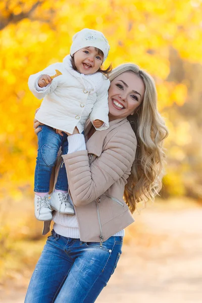 Mamá e hija descansando en un parque en otoño — Foto de Stock