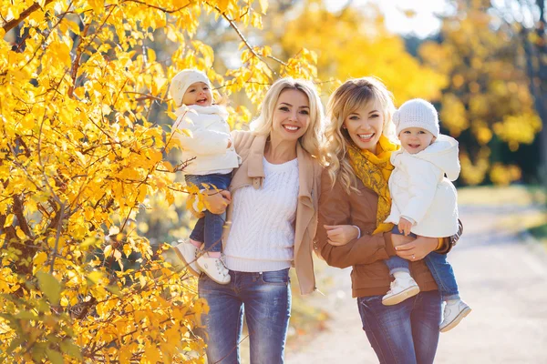 Moms and kids for a walk in the park in autumn — ストック写真