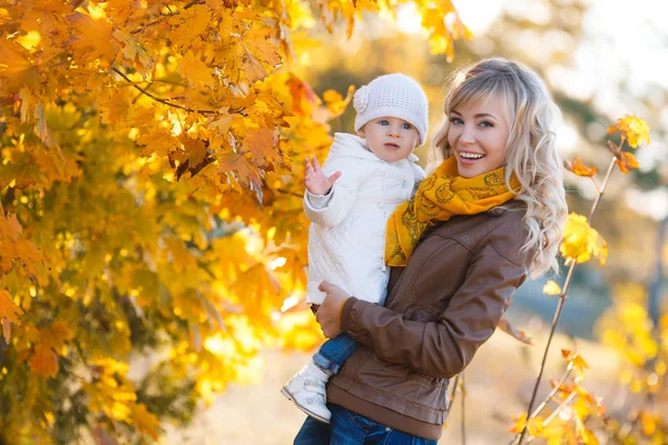 Mom and daughter resting in a park in autumn — Stock Photo, Image