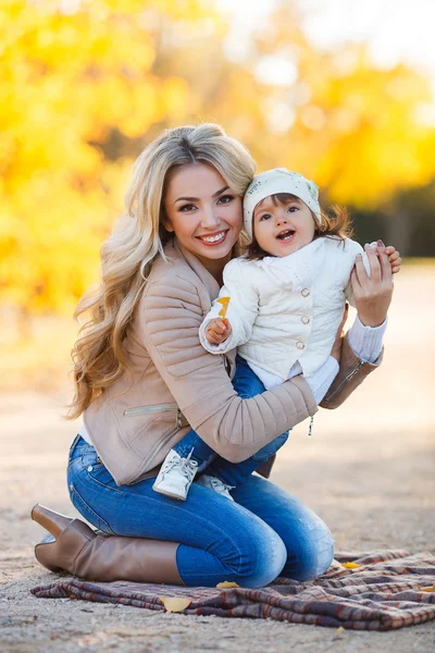 Mamma e figlia riposano in un parco in autunno — Foto Stock