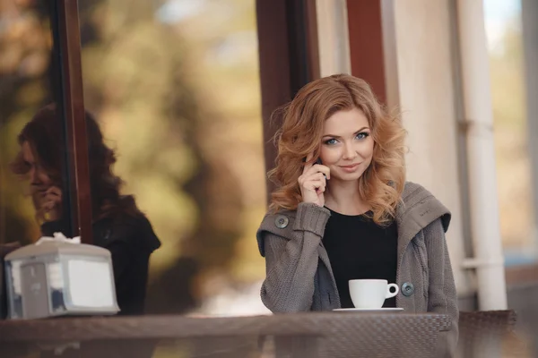 Femme buvant un café à une table dans un café — Photo