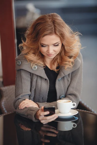 Mujer tomando café en una mesa en un café —  Fotos de Stock