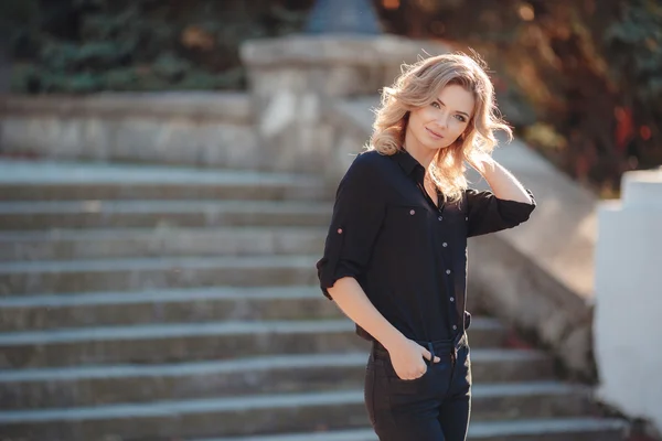 Portrait of a beautiful blonde in the Park on the stairs — Stock Fotó
