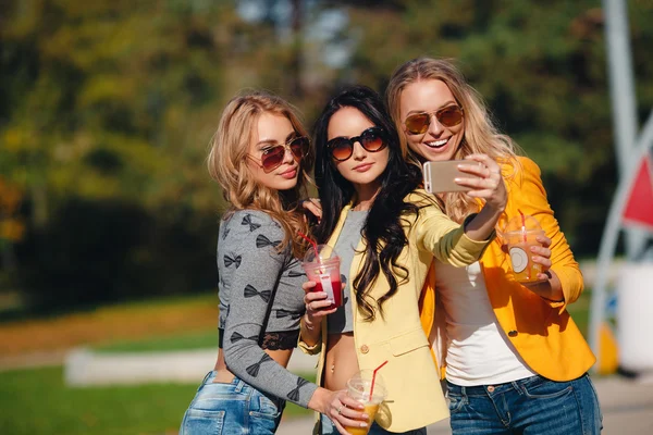 Drei schöne Frauen machen ihr Selfie auf dem Smartphone — Stockfoto