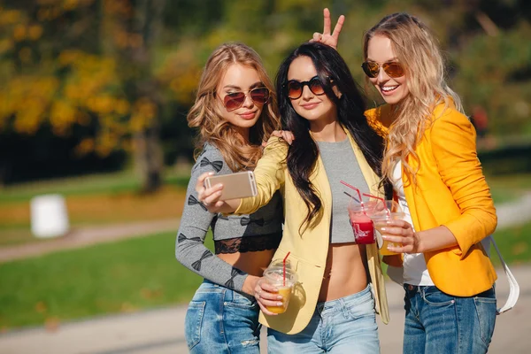 Drei schöne Frauen machen ihr Selfie auf dem Smartphone — Stockfoto