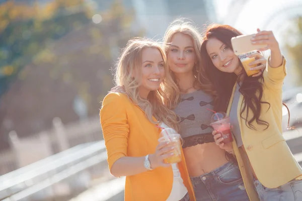 Drei schöne Frauen machen ihr Selfie auf dem Smartphone — Stockfoto