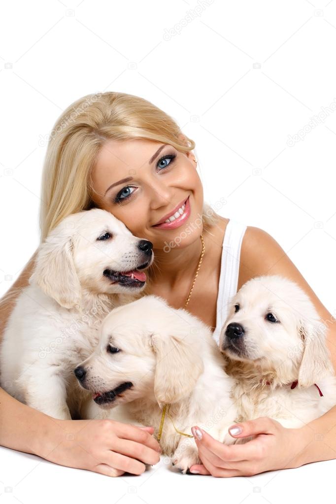 Beautiful blonde with a small white puppy of Labrador