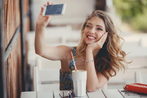 Young woman taking a self portrait (selfie) with smart phone in a Parisian street cafe — Stock Photo, Image