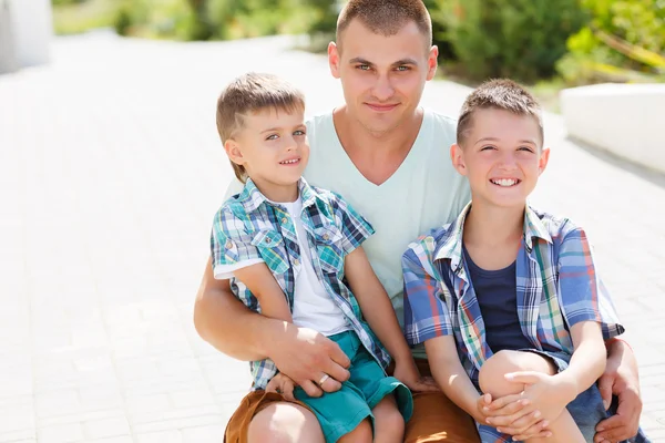 Jovem pai feliz com seus dois filhos — Fotografia de Stock
