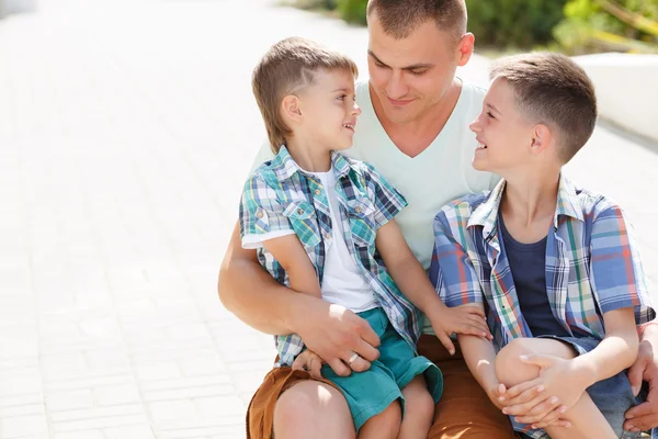 Feliz joven padre con sus dos hijos — Foto de Stock