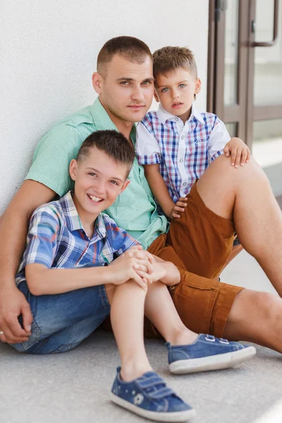 Jovem pai feliz com seus dois filhos — Fotografia de Stock