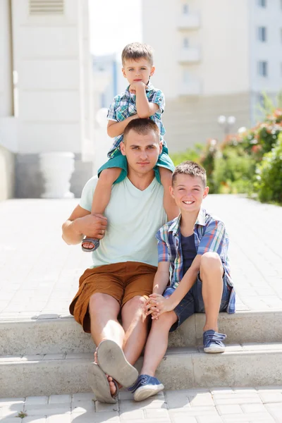 Jovem pai feliz com seus dois filhos — Fotografia de Stock