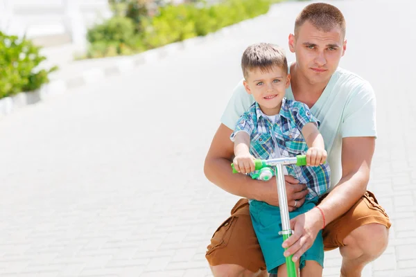 Father teaching son to ride a scooter — Stock Photo, Image