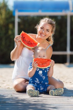 Anne ve genç oğlu, karpuz yemek