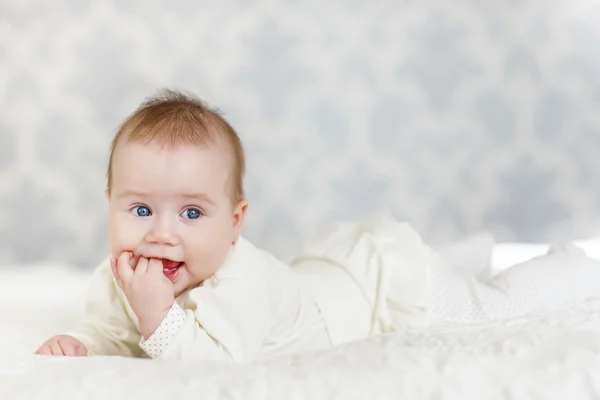 Retrato de um bebê rastejando na cama em seu quarto — Fotografia de Stock