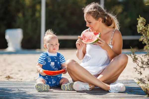 Moeder en jonge zoon, eten rijp watermeloen — Stockfoto