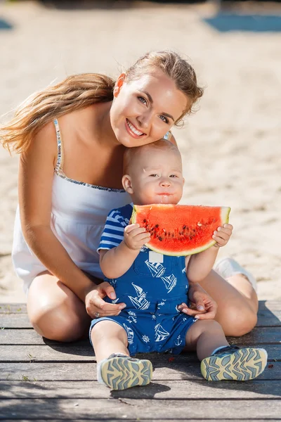 母と若い息子の熟したスイカを食べる — ストック写真