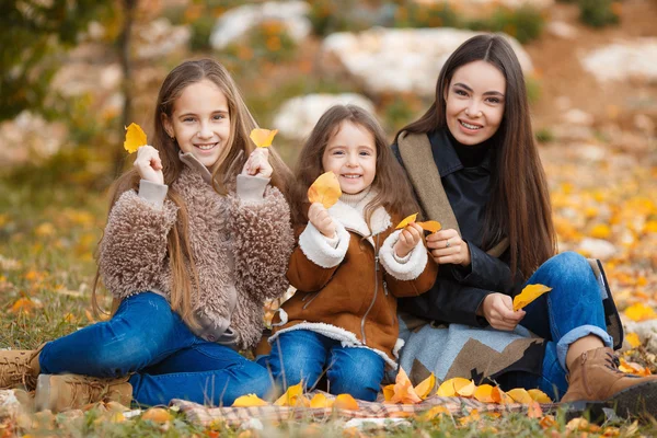 Семейный портрет сестры в желтом осеннем парке — стоковое фото