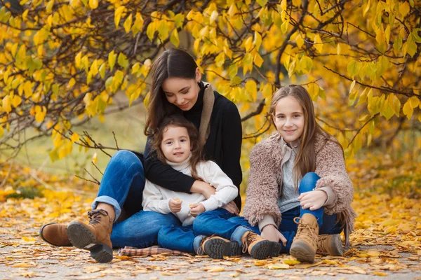 Family portrait of sisters in yellow autumn Park — Stok fotoğraf