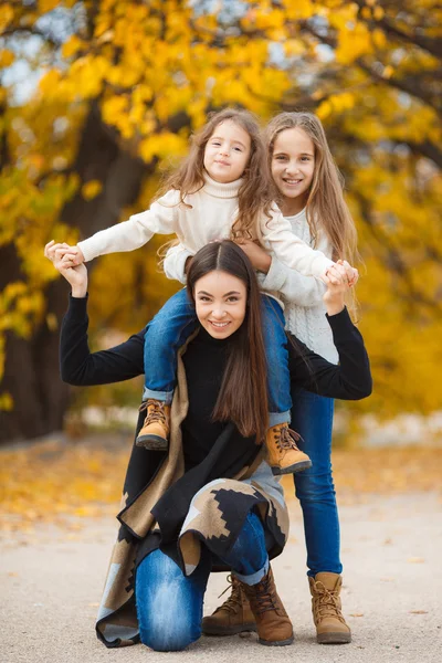 Family portrait of sisters in yellow autumn Park — Stock Photo, Image