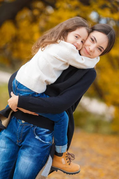 Mãe feliz e a filha caminham no parque no outono — Fotografia de Stock