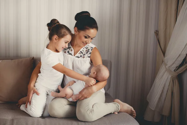 Porträtt av en mamma med två barn hemma — Stockfoto