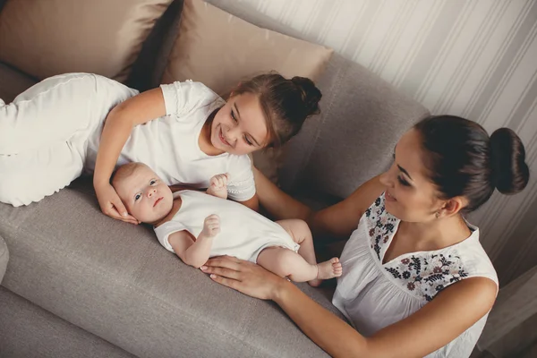 Porträtt av en mamma med två barn hemma — Stockfoto