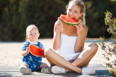 Anne ve genç oğlu, karpuz yemek