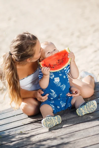 母と若い息子の熟したスイカを食べる — ストック写真