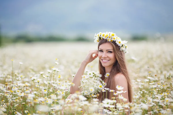 Beautiful young woman in a field of blooming daisies — 图库照片