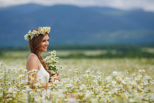 Beautiful young woman in a field of blooming daisies — Φωτογραφία Αρχείου