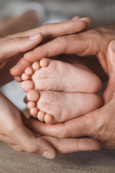 Los pies de los niños en manos de la madre y el padre . —  Fotos de Stock