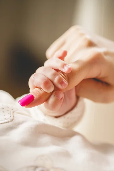 Newborn baby holding mother's finger — Stock Photo, Image