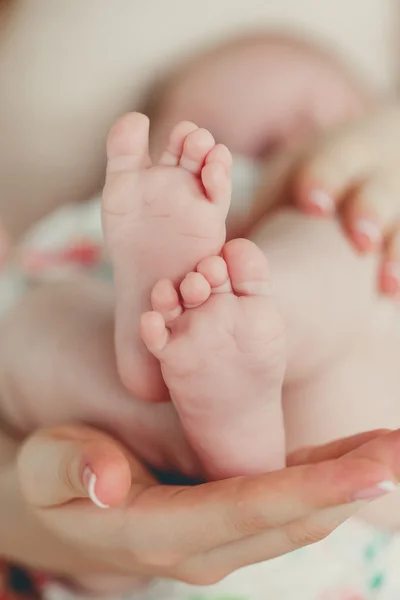 Jambes d'enfants sur la paume d'une mère — Photo