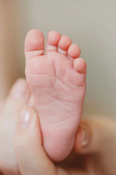 Jambes d'enfants sur la paume d'une mère — Photo