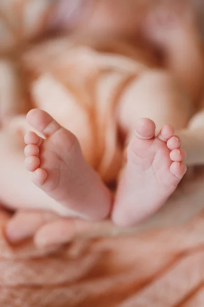 Jambes d'enfants sur la paume d'une mère — Photo