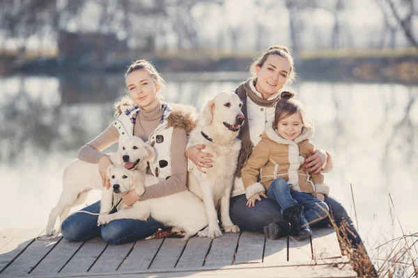 Familia feliz con mascotas cerca del lago — Foto de Stock