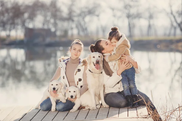 Famille heureuse avec animaux de compagnie près du lac — Photo