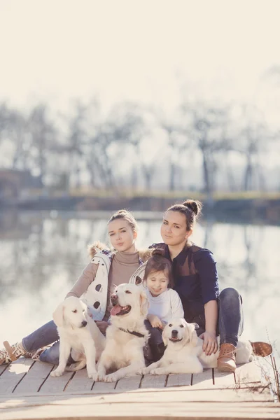 Счастливая семья с домашними животными у озера — стоковое фото
