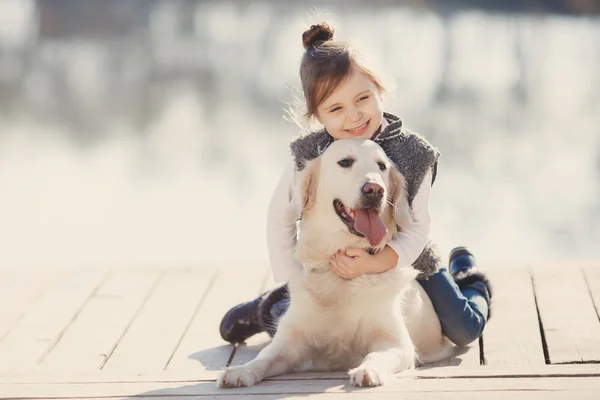 Little girl with his beloved dog at the lake — 图库照片