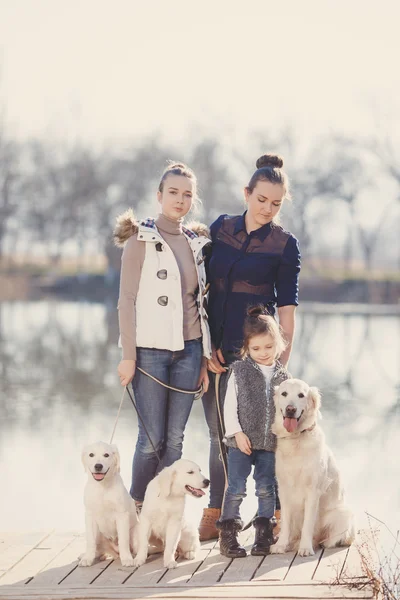 Familia feliz con mascotas cerca del lago — Foto de Stock