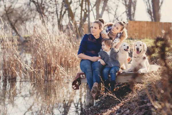 Família feliz com animais de estimação perto do lago — Fotografia de Stock