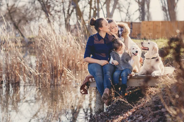 Família feliz com animais de estimação perto do lago — Fotografia de Stock
