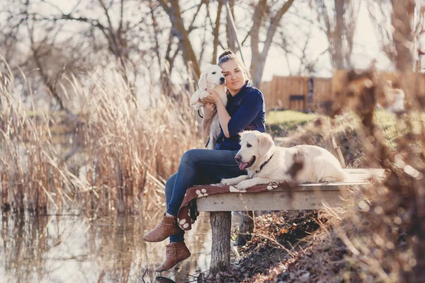 Красива дівчина з домашніми тваринами біля озера — стокове фото