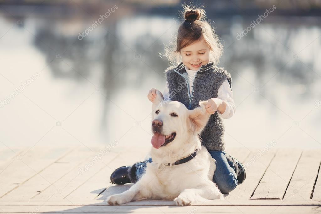 Little girl with his beloved dog at the lake